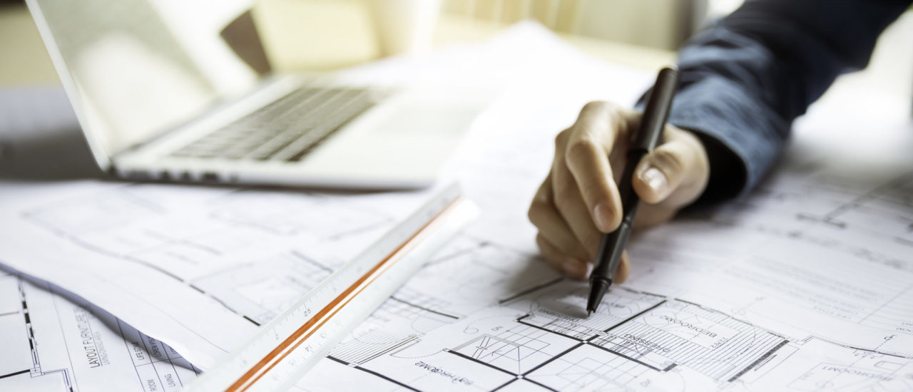 Close up woman hand working of Architect sketching project on blueprint at site construction work. Concept of architect, engineer in the office desk construction project banner